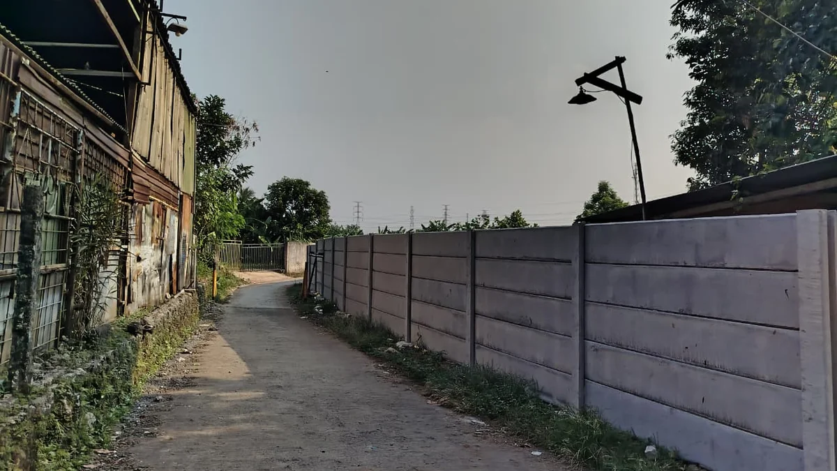 Pagar beton precast rapi di sisi jalan gang permukiman