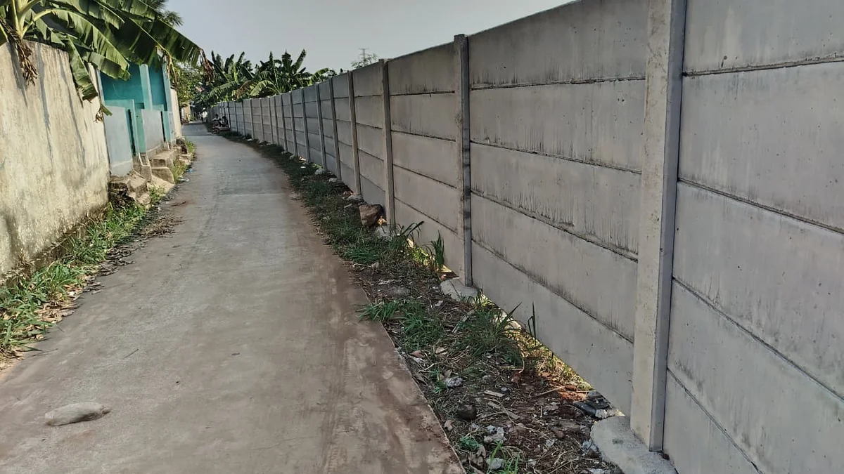 Pagar beton berdiri rapi di samping jalan gang sempit